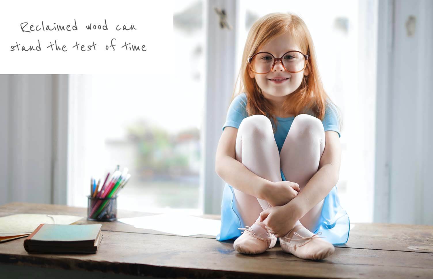 child sitting on reclaimed wooden furniture 